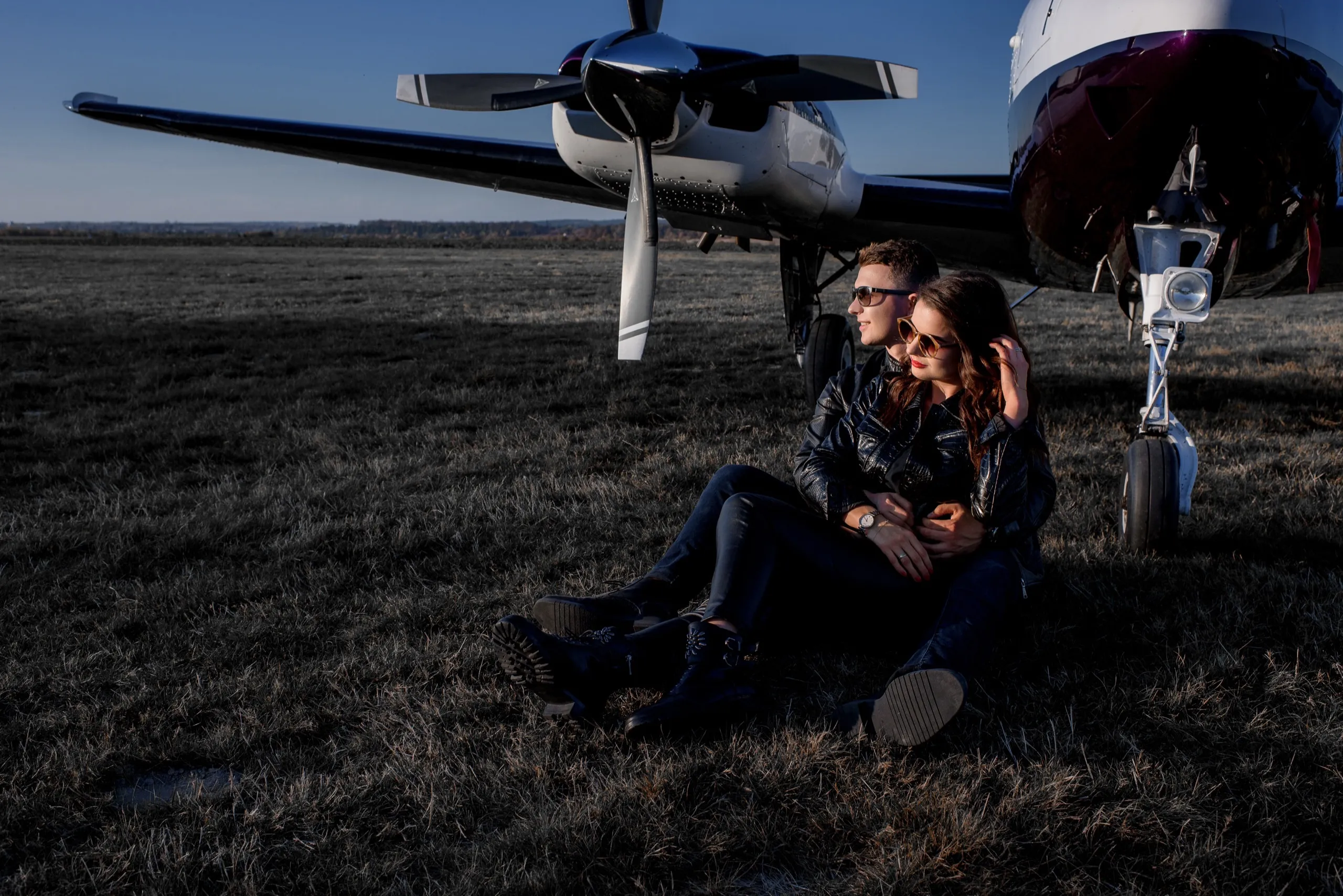 attractive-couple-love-is-hugging-each-other-sitting-ground-near-helicopter-sunny-day.jpg